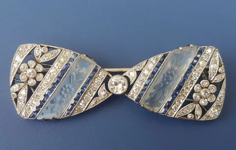 20th century platinum bow-tie shaped brooch set with numerous small diamonds and sapphires